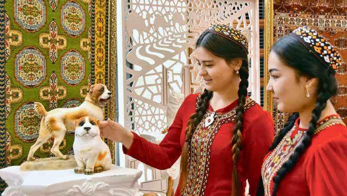 turkmen-girls-on-natinal-clothes-with-dog-statues-alabay