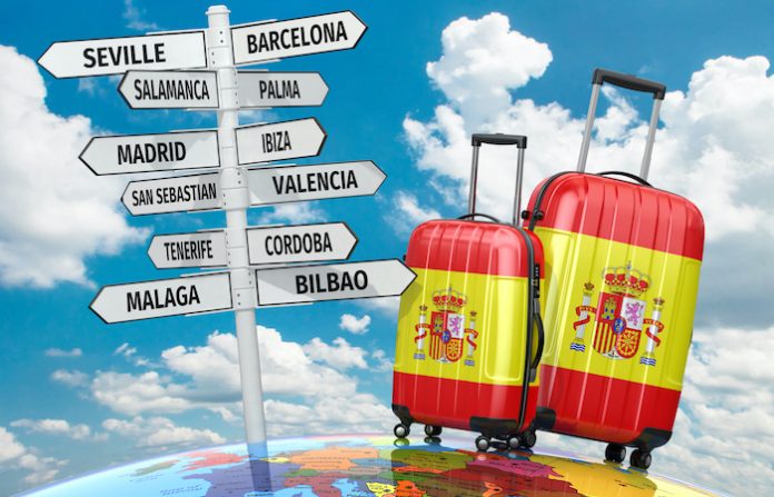 Travel concept. Suitcases and signpost what to visit in Spain
